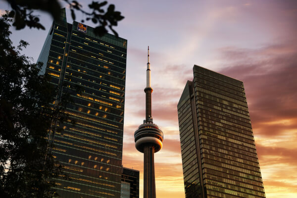A photo of the CN Tower sandwiched between two towers.